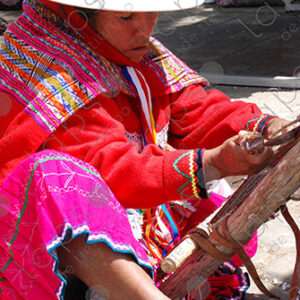 A woman in traditional attire weaving on a loom