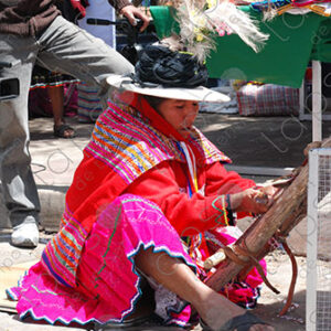 A woman in traditional attire weaving on a loom