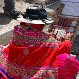 A woman in traditional attire weaving on a loom