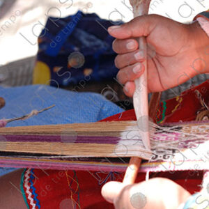 Detail of hands with bones, weaving on a loom