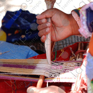 Detail of hands with bones, weaving on a loom