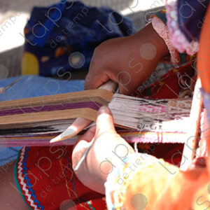Detail of hands with bones, weaving on a loom