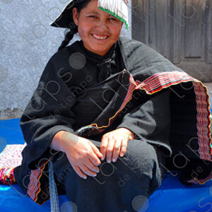 Indigenous woman dressed in black and decorated hat