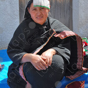 Indigenous woman dressed in black and decorated hat