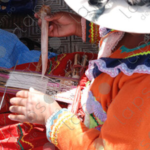 Indigenous woman weaves on a loom