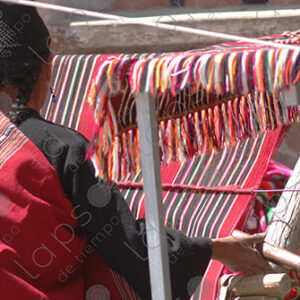 Indigenous woman working on a red loom