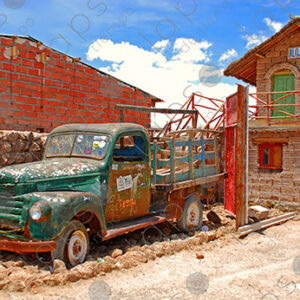 Old green pickup truck at old house in the desert