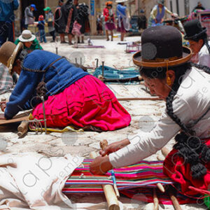 Several weavers on the floor with their looms