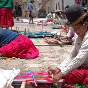 Several weavers on the floor with their looms