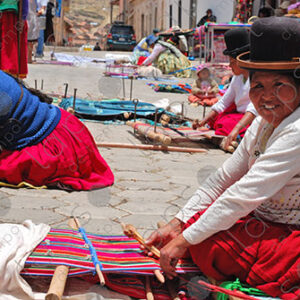 Several weavers on the floor with their looms