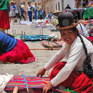 Several weavers on the floor with their looms