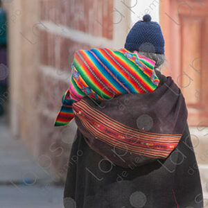 Woman walks away, holding two aguayos
