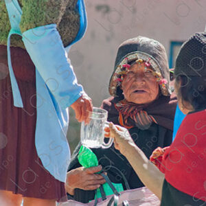 Women with an elderly man in traditional attire and helmet, Tarabuco, Bolivia
