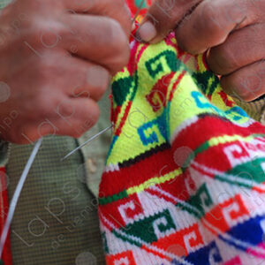 Detail of a mans hands knitting a hat