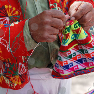 Detail of a mans hands knitting a hat