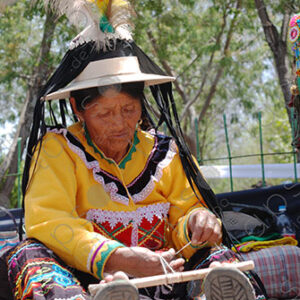 Indigenous old woman weaves with a foot loom