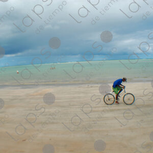 Boy riding a bicycle in the sand