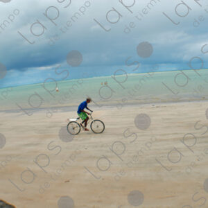 Boy riding a bicycle in the sand