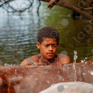 Boys bathing with horses in the river