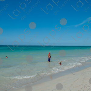 Man and his daughter bathing in the turquoise sea