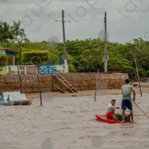Men on a small raft in the middle of the river.