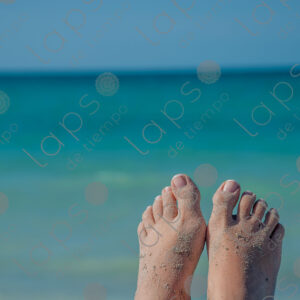 Pale-skinned woman's feet with sand