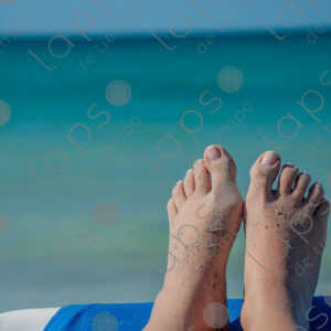 Pale-skinned woman's feet with sand