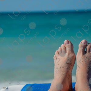 Pale-skinned woman's feet with sand