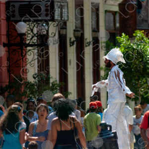 People on the street, man on stilts