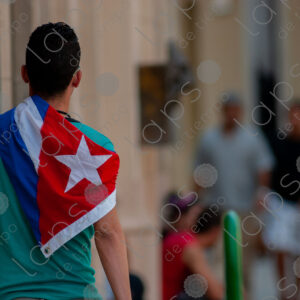 Young man carries a Cuban flag on his back