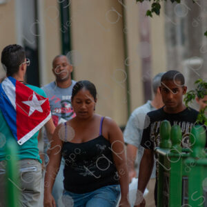 Young man carries a Cuban flag on his back