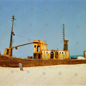 Abandoned boat on Saint-Louis beach and Senegalese man