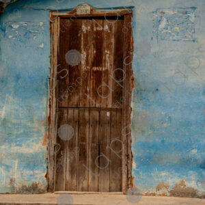 Detail of the blue entrance door of a rustic house
