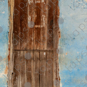 Detail of the blue entrance door of a rustic house