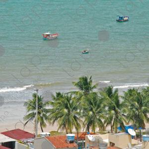 Landscape with houses and a turquoise sea background with two boats.